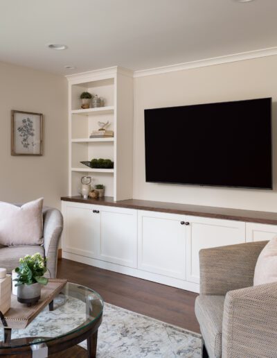 A living room with a flat screen tv and bookshelves.