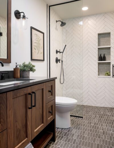 A bathroom with a white tiled floor and a wooden vanity.