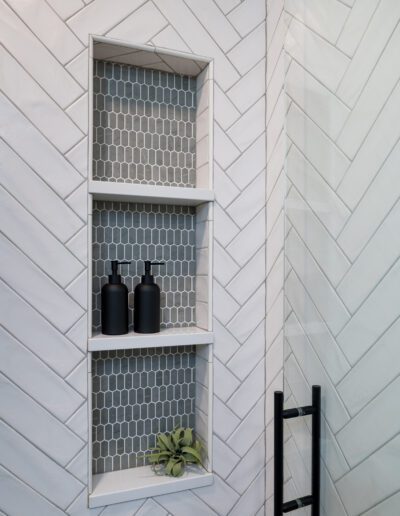 A bathroom with a herringbone tiled wall.