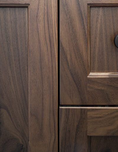 A close up of a wooden cabinet with a black knob.