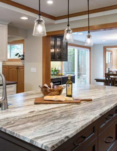 A kitchen with marble counter tops and stainless steel appliances.