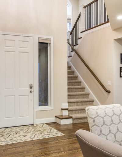 A living room with hardwood floors and a staircase.