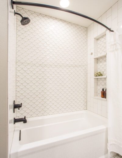 A white and black bathroom with a tub and shower.