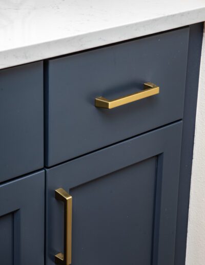 A blue cabinet with brass handles and knobs.