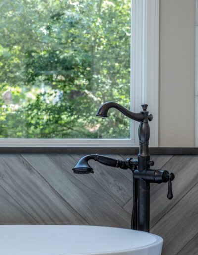 A bathtub in a bathroom with a window.