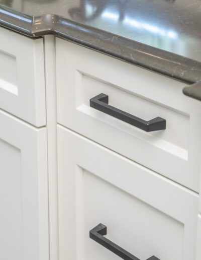 A white kitchen with black drawer pulls.