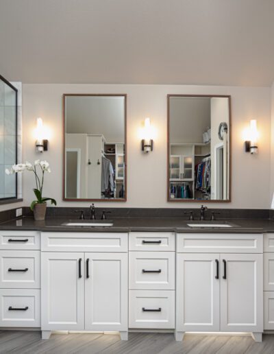 A bathroom with two sinks and a walk in shower.