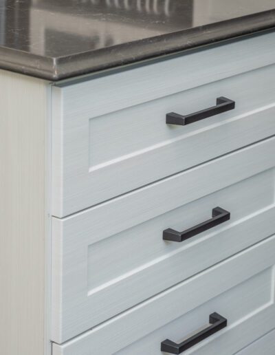 A white dresser with drawers and a counter top.