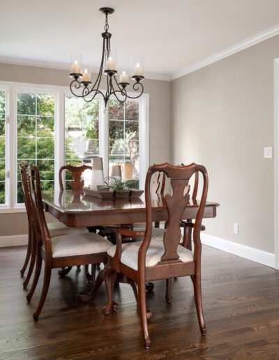 A dining room with hardwood floors and a chandelier.